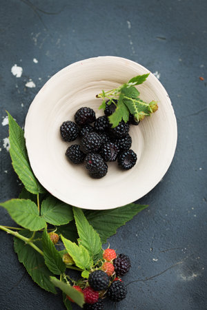Blackberries and raspberries in a clay bowlの写真素材