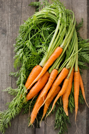 Fresh juicy farm carrot with green top, top viewの写真素材