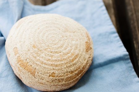 A round loaf of bread on a blue napkinの写真素材