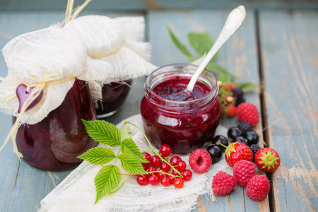 Delicious berry jam in a jar in the summer gardenの写真素材