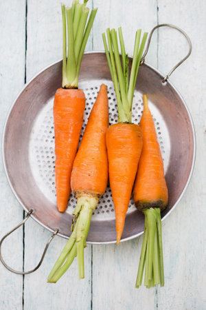 Fresh juicy farm carrot with green top, top viewの写真素材
