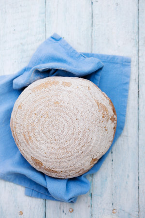 A round loaf of bread on a blue napkinの写真素材