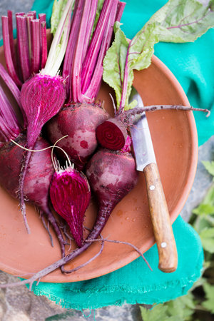 Fresh organic beets, with tops in a bowlの写真素材
