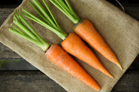 Fresh juicy farm carrot with green top, top viewの写真素材