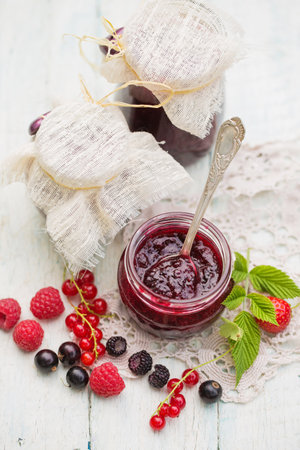 Delicious berry jam in a jar in the summer gardenの写真素材