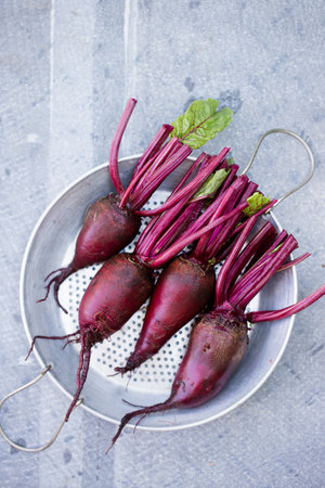 Fresh organic beets, with tops in the sieveの写真素材
