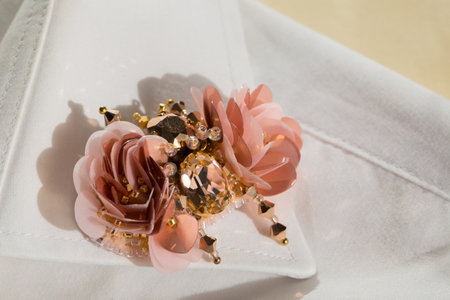 Handmade brooch beetle made of stones and sequins on the collar of a white shirt on a beige backgroundの写真素材
