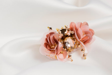 Decorative handmade brooch on white silk fabricの写真素材