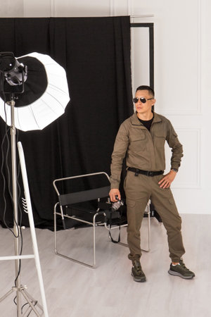 A young male photographer with a camera in a photo studioの写真素材