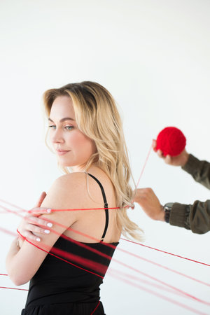 A man wraps red threads around a woman. Dependency concept
