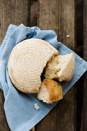 A round loaf of bread is broken into piecesの写真素材
