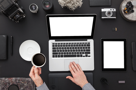 Work space on black table of a creative designer or photographer with laptop, tablet, cameras other objects of inspiration and copy space. Stylish home studio concept of technology trends.の写真素材