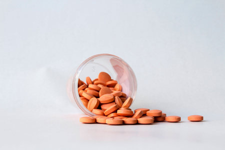 Prescription pill bottle spilling pills on to surface isolated on a white background. Orage medicine for pataint in hospital and people who feel sick,ill.の写真素材