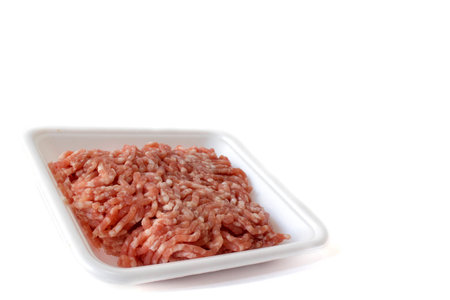 Isolated minced red pork on white plastic container package background; minced pork use for cooking...
