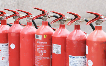 Fire extinguisher in a row. The fire extinguisher is red.