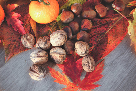 Autumn still life with chestnuts and tangerines on wooden backgroundの写真素材