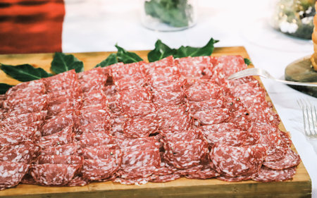 Slices of salami on a wooden board. Selective focus.の写真素材