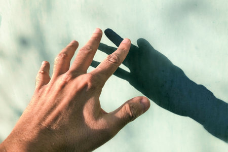 Man's hand with shadow on the wall. Selective focus.の写真素材