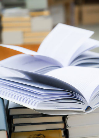 Stack of books on the table in library. Selective focus.