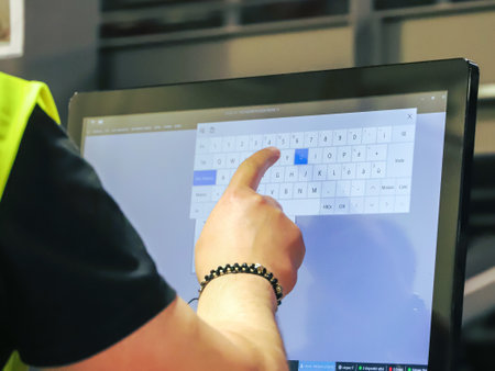 Closeup of man's hand pointing at a calendar on a computer screenの写真素材