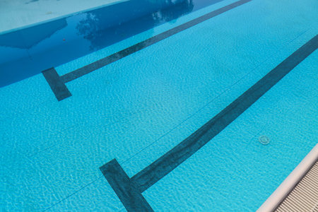 Swimming pool with blue water and stairs in a hotel resort.の写真素材