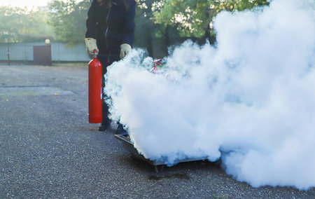Fire extinguisher in the hands of a man. Smoke from a fire extinguisher.の写真素材