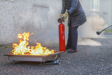 Firefighters extinguish a fire with a fire extinguisher on a street.