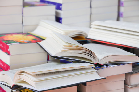 Open book, hardback books on shelf in library. Back to school. Copy space.