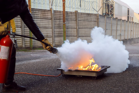 Firefighter extinguishing a fire with a fire extinguisher on the street