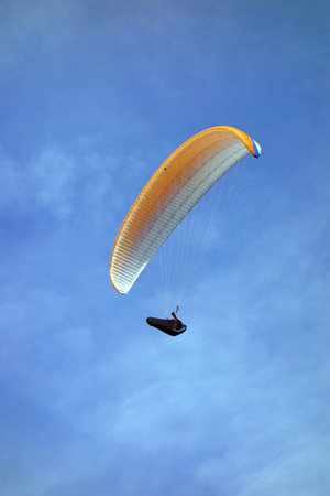 paraglider flying high in the sky