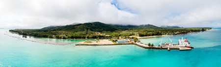 Tubuai island, French Polynesia - Nov 08 2017: An aerial drone view of Tubuai island and azure turquoise blue lagoon. Ship Tuhaa Pae IV unloading in the port of Mataura, Tubuai, Austral islands.のeditorial素材