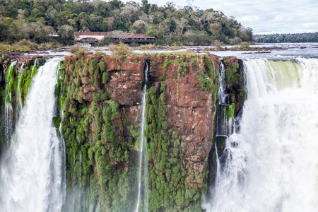Building on a cliff over waterfall. Winter view of Iguazu Falls Devil's Throat under heavy clouds lead sky. Border of Brazil and Argentina. Latin America. South America.の写真素材
