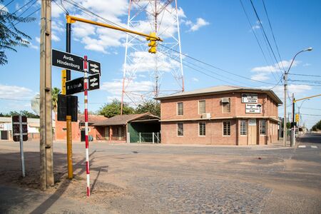 FILADELFIA, PARAGUAY - July 15, 2018: City centre of Filadelfia, Boqueron Department, Gran Chaco, Paraguay. Deutsch mennonite colony. Traffic lights and street name signs on red-white pillar.のeditorial素材