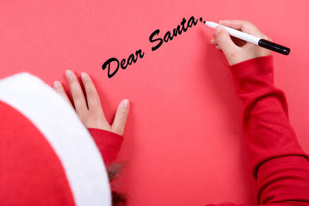 young woman with christmas hat writing a letter to Santa Clausの写真素材