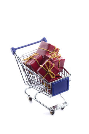 shopping cart full with red christmas present box isolated on white backgroundの写真素材