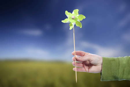 Young woman holding pinwheel windmill outdoors - spring conceptの写真素材