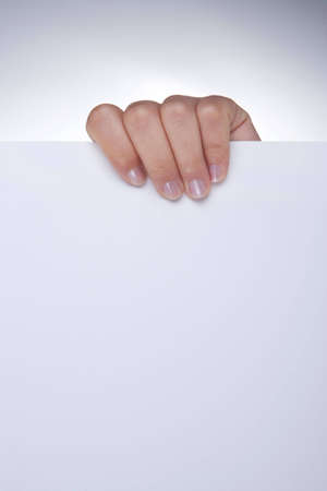 woman hand holding white blank paper - portrait orientationの写真素材