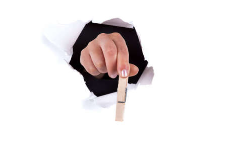 woman hands holding clip thru white wall holeの写真素材