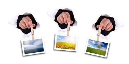 woman hands holding clip thru white wall holeの写真素材