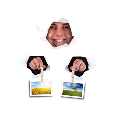 young woman holding landscape photos thru wall hole - square formatの写真素材