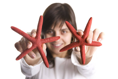 young woman playing with red starfish seashell