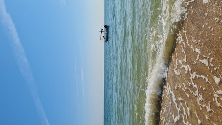 Aerial view of a fisherman in a boat at the beach.の写真素材
