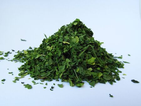 A bitter dried green parsley spice on a white backgroundの写真素材