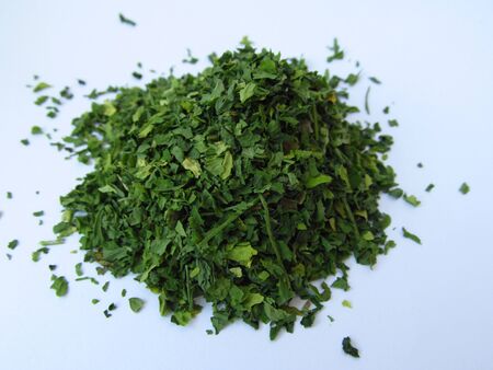 Dried green parsley spice on a white backgroundの写真素材