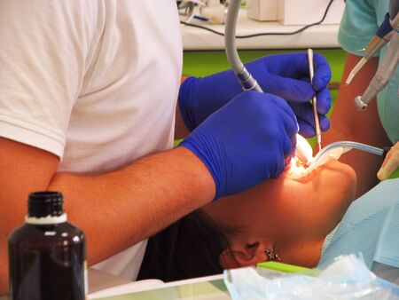 The process of teeth treatment for a young girl in a dental clinicの写真素材