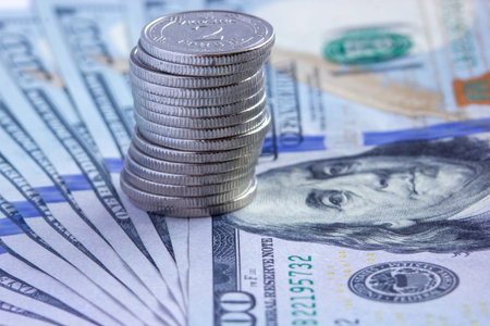 Selective focus. Coins of Ukrainian hryvnia and one hundred dollar bills. Currency exchange...