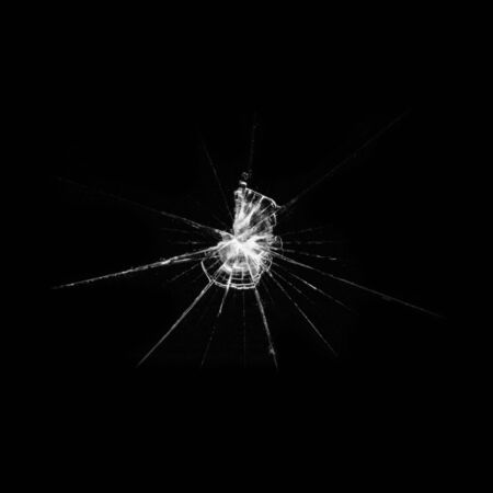 A crack of broken glass from the impact of a vandal on a window. Illustration of a destroyed showcase on a dark background.の写真素材