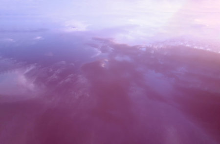 Background of pink water in the lake and reflected sky. Abstraction of nature.