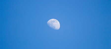 Moon on a blue sky background in the afternoon