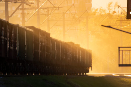 Train cars on railway tracks. Sunlight that penetrates the fog and creates beautiful rays. Motion...